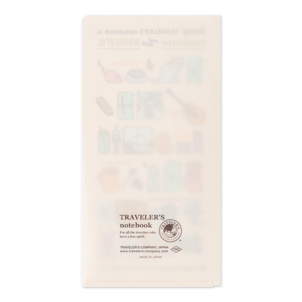 A cream-colored paper notebook with a translucent, frosted cover featuring faint pastel illustrations of travel items and the text 'TRAVELER'S notebook' printed near the bottom.