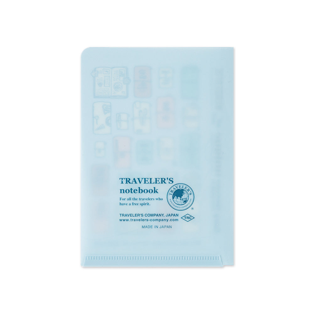 A light blue translucent plastic notebook cover with embossed travel icons and printed blue text reading 'TRAVELER'S notebook' and 'Traveler's Company, Japan' on a white background.