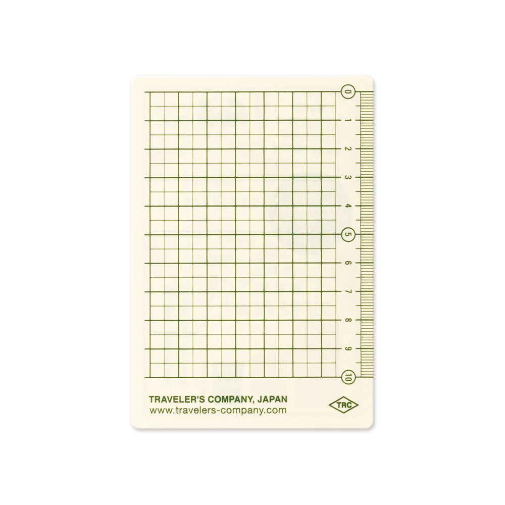 A rectangular measuring grid card with green lines on a cream background, featuring measurement markings along the right edge and printed text at the bottom reading Traveler's Company, Japan.