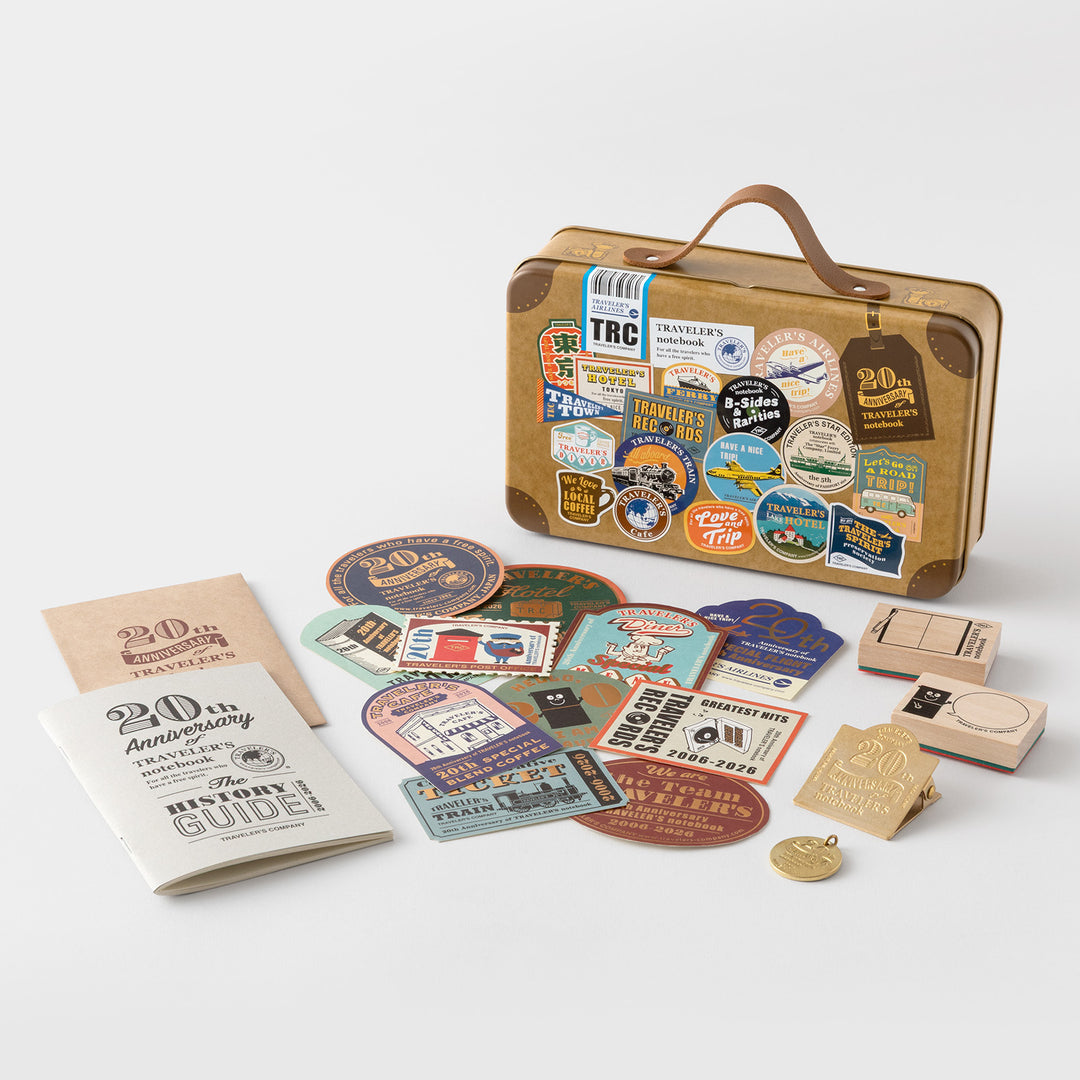 Open suitcase tin showing illustrated interior lid with Traveler&