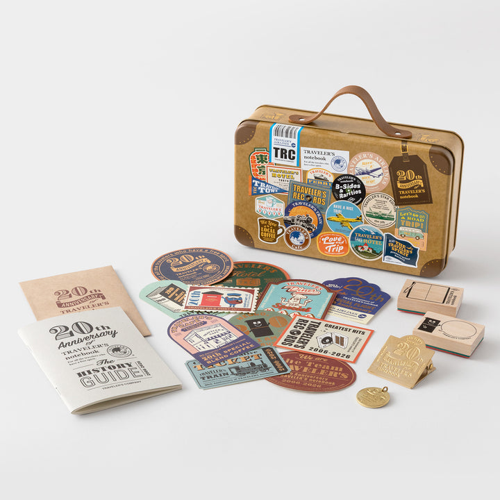 Open suitcase tin showing illustrated interior lid with Traveler&