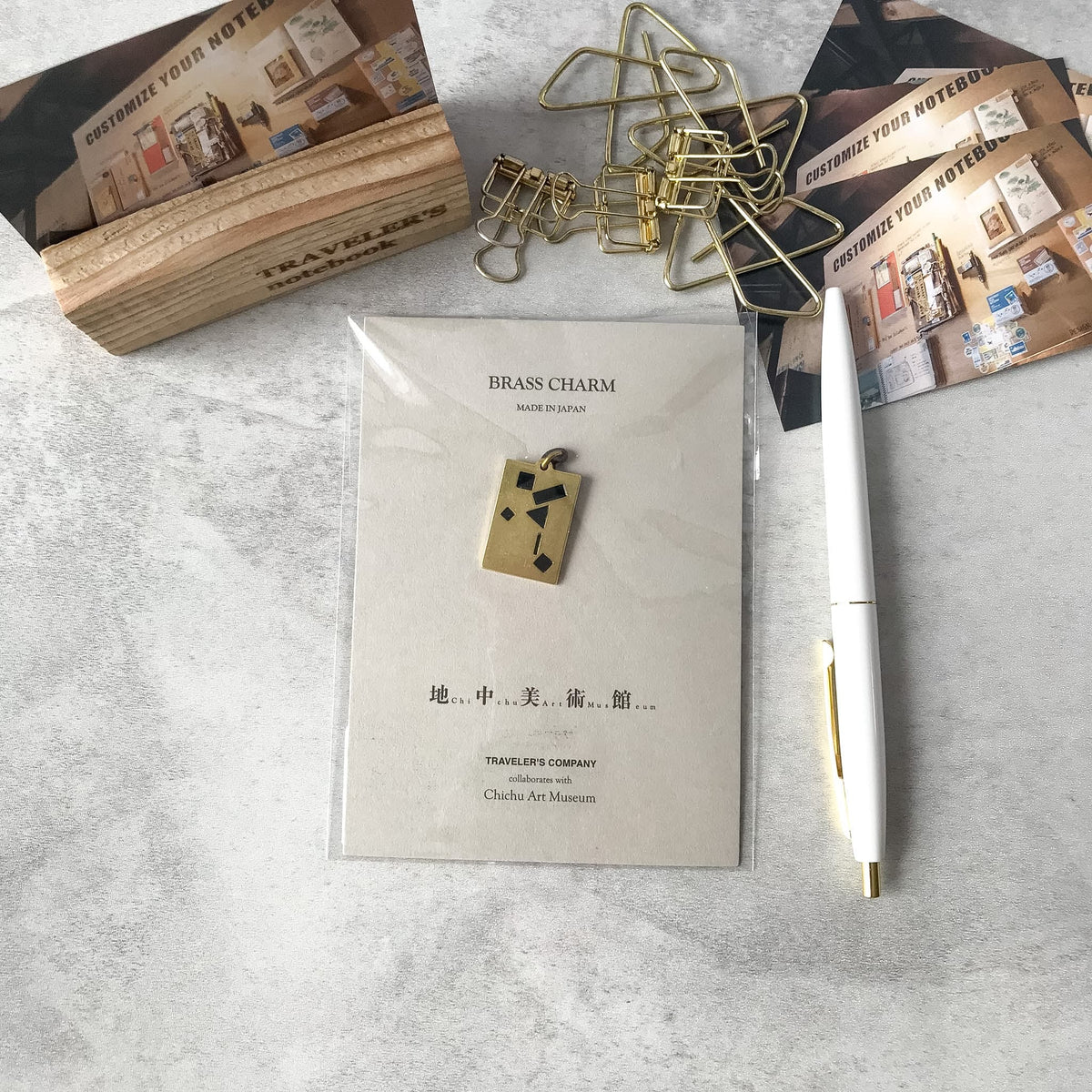 Traveler’s Factory Chichu Art Museum brass charm and packaging in a stationery flat lay