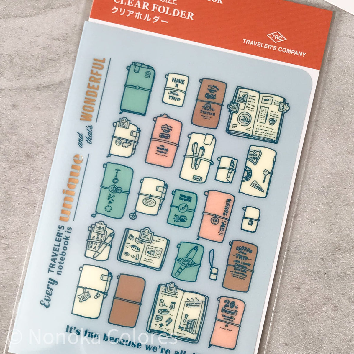 A clear plastic notebook folder sheet from Nonoko Shop featuring multiple illustrated notebook covers and stationery designs in pastel colors, shown on a light gray textured surface.
