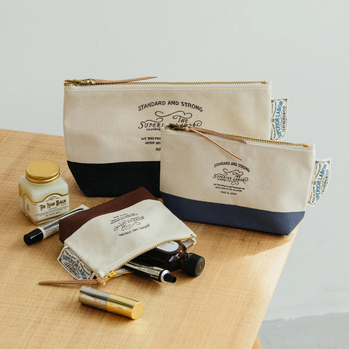 Close-up of the genuine brass hardware and The Superior Labor brand stamp on a canvas engineer pouch.