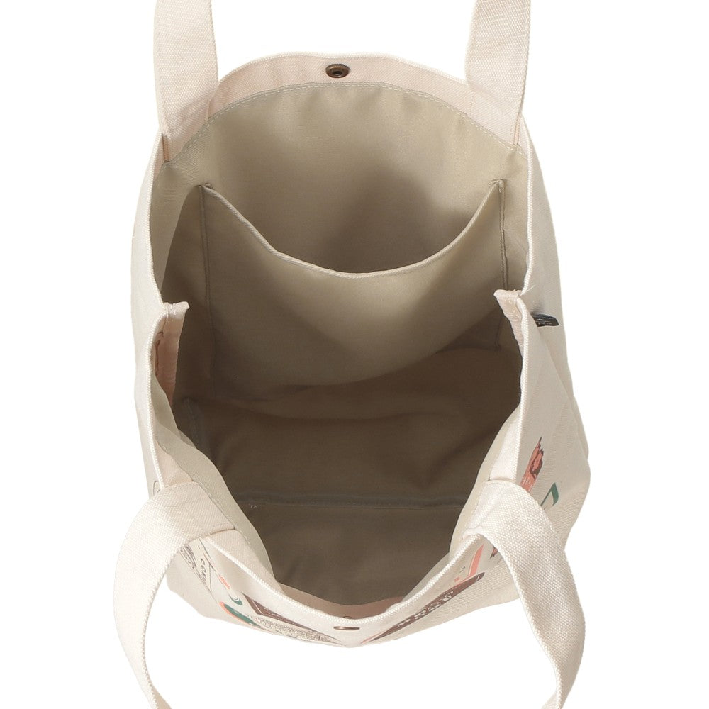 An overhead view of a canvas tote bag showing its interior, which features a large central organizer pocket and a light beige lining. The bag is made of a natural off-white canvas with a small colorful floral print visible on the right side, set against a plain white background.